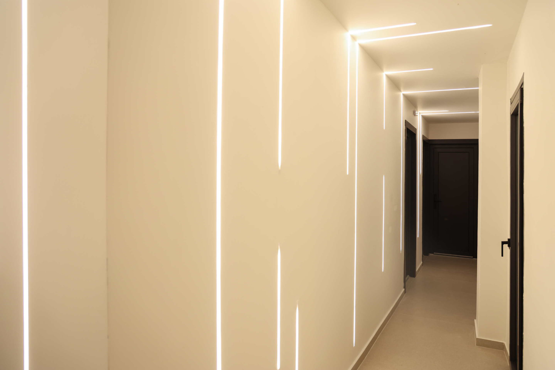 Interior corridor with warm recessed lighting leading to the studio entrances