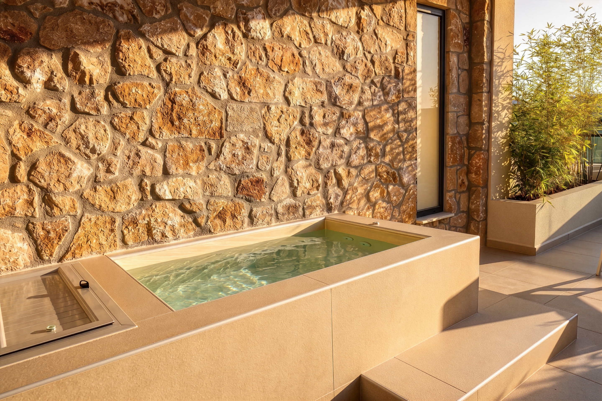 Private Jacuzzi filled with water beside a natural stone wall