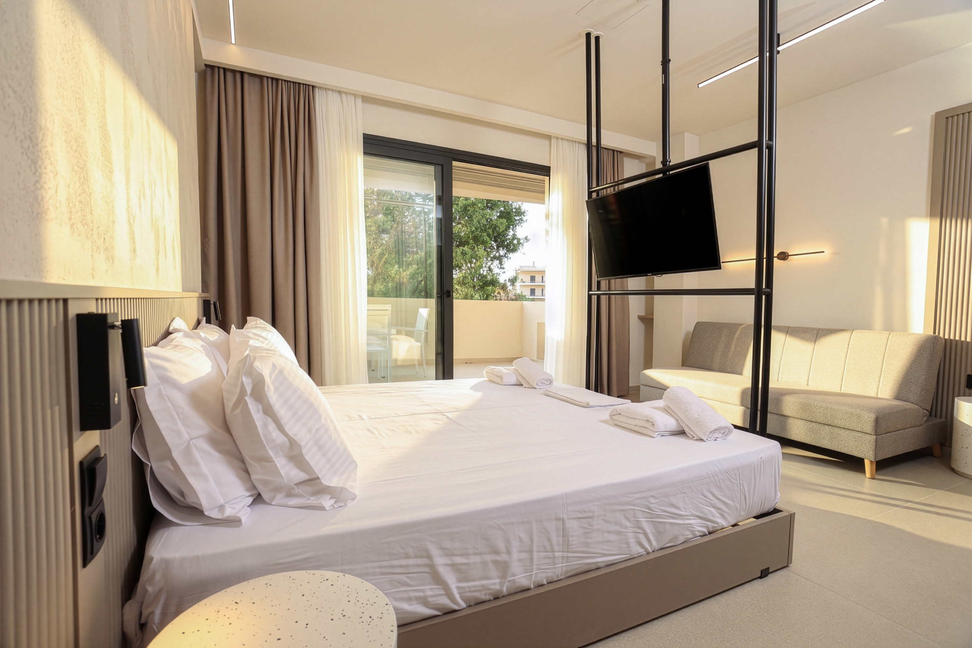 Family studio bed facing the balcony doors, with sofa and television alongside