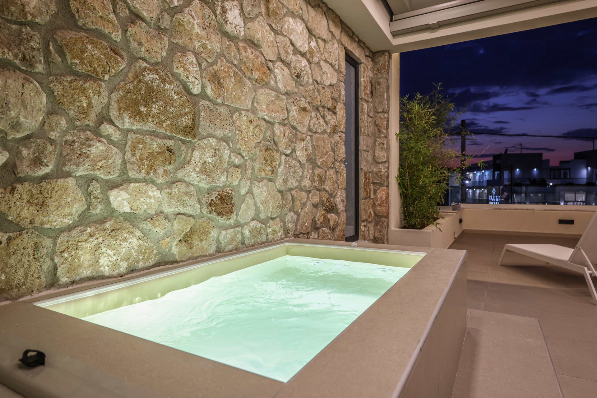 Private Jacuzzi glowing on the balcony against a deep blue evening sky