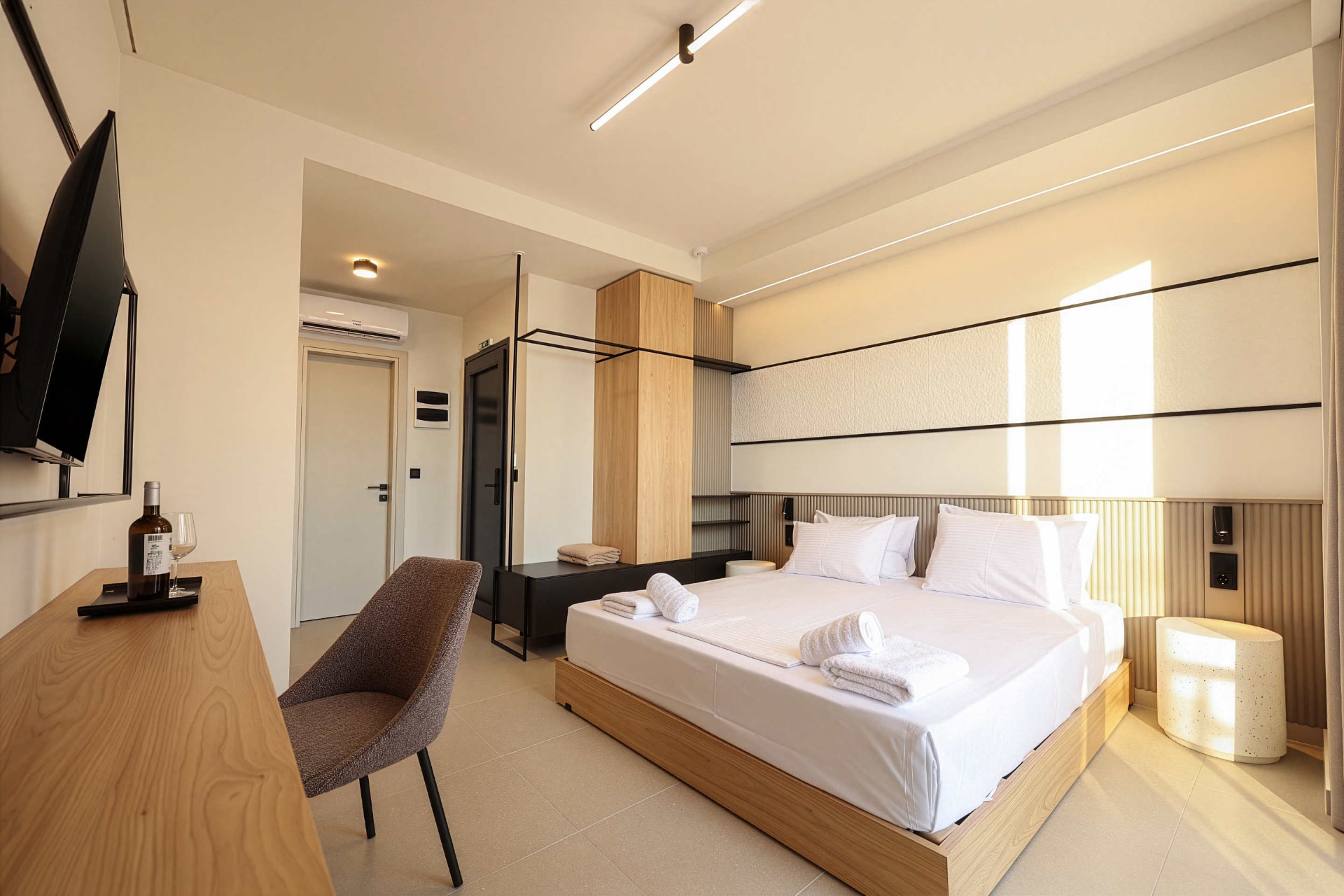 King Studio interior with oak desk, wardrobe and bed in afternoon light