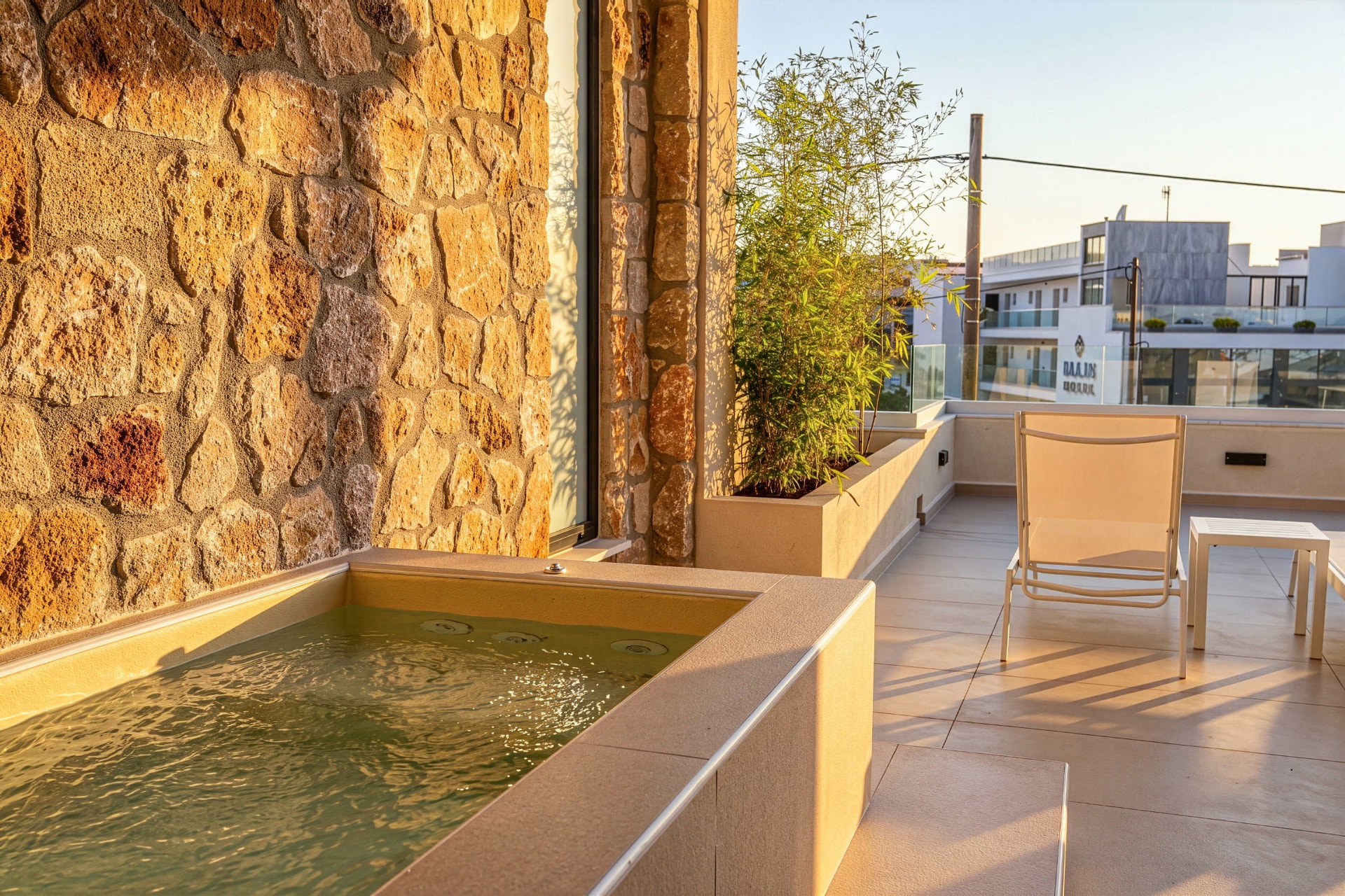 King Studio private balcony with Jacuzzi and sun lounger in golden light