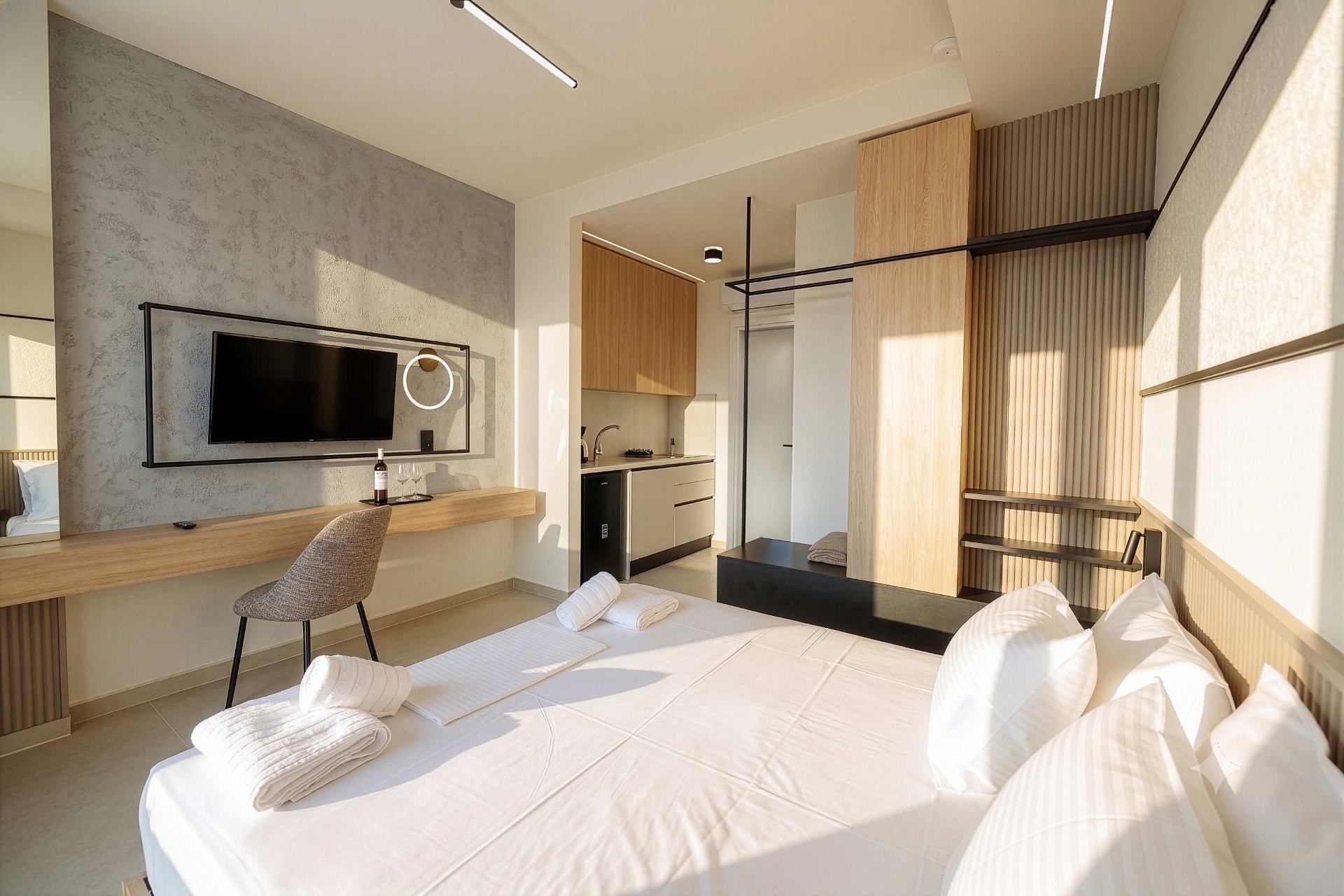 King Studio seen from the bed, with desk, television and kitchenette beyond