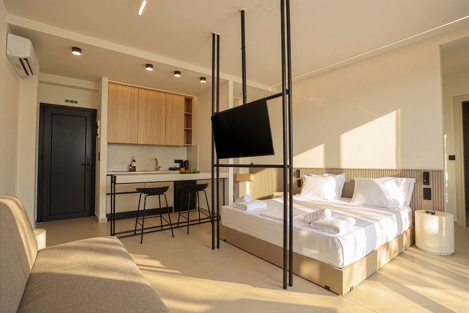 King Studio with Sofa Bed: king-size bed, breakfast bar and kitchenette in morning light